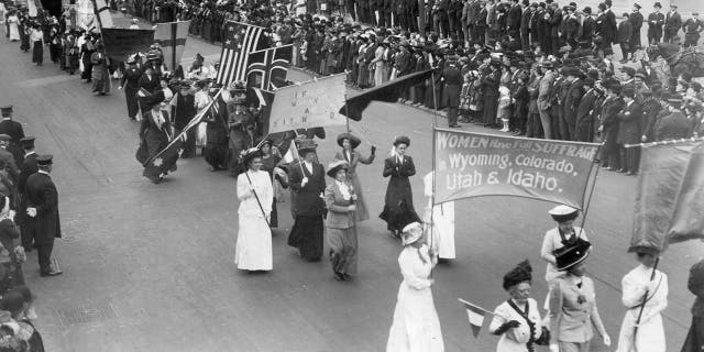 Suffragettes carry a banner announcing that "women have full suffrage in Wyoming, Colorado, Utah and Idaho" at the Women of all Nations Parade in New York on May 3, 1916.