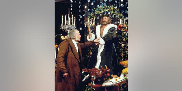 George C. Scott (at left) stars as the stingy businessman Ebenezer Scrooge, and Edward Woodward (at right) is the Ghost of Christmas Present, in "A Christmas Carol," Charles Dickens' classic holiday tale. Originally broadcast on CBS on Dec. 17, 1984. Image dated April 1, 1984.