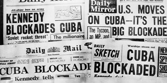 Headlines of Britain's daily newspapers on Oct. 23 announcing President Kennedy's blockade of Cuba. U.S. planes and ships, armed with orders to shoot if necessary, began taking up positions in the Caribbean on Oct. 22 to cut off shipments of Communist offensive weapons to Cuba. Kennedy told the nation that Soviet missiles and other weapons had turned Cuba into an armed camp capable of hurling destruction into the heart of America.