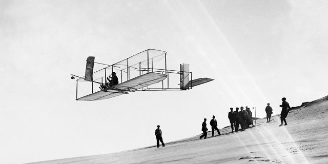 Orville Wright flies a glider over Kill Devil Hills.