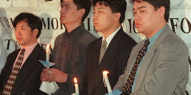 Los líderes estudiantiles chinos realizan una vigilia con velas frente a la Embajada de China en Washington el 3 de junio para conmemorar el séptimo aniversario de la Masacre de Tiananmen.  Los estudiantes que lideraron las protestas de Tiananmen luego escaparon de China, en la foto de izquierda a derecha: Liu Gang, Zhou Fengsuo, Chen Tong y Wuer Kaixi. 