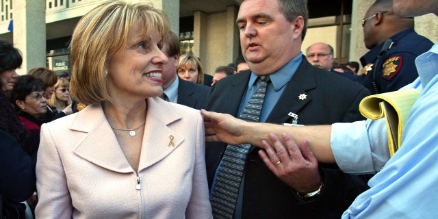 Sharon Rocha, Laci Peterson's mother, walks out to stand with her husband as he addresses the media outside the courthouse after the formal sentencing of Scott Peterson March 16, 2005, in Redwood City, Calif.