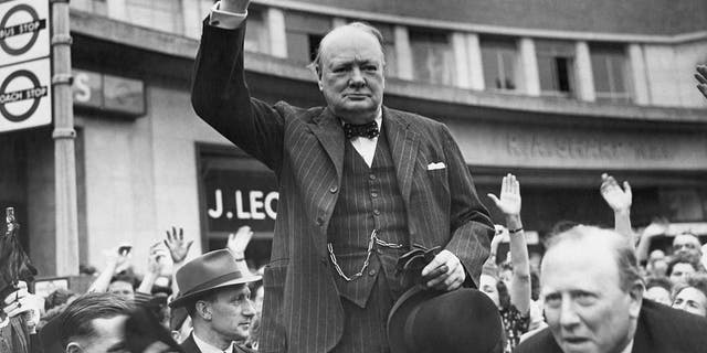 Sir Winston Churchill, en campagne pour sa réélection au siège du premier ministre, donne le "V" signe de victoire aux personnes lors d'un rassemblement à Uxbridge.