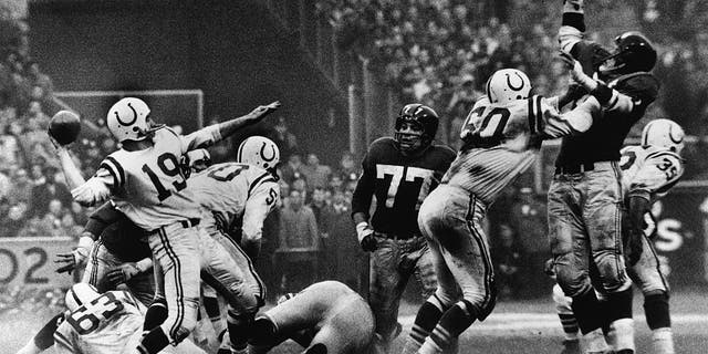American quarterback Johnny Unitas (left) of the Baltimore Colts is shown as he's about to throw a pass during a play in "sudden death" overtime of the NFL Championship game against the New York Giants, Yankee Stadium, New York, Dec. 28, 1958. The Colts won 23-17.