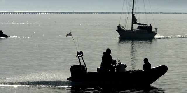 With the San Francisco skyline in the background, a police boat patrols the waters for signs of missing woman Laci Peterson Jan. 4, 2003, in Berkeley, Calif.