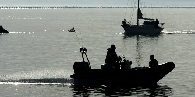 With the San Francisco skyline in the background, a police boat patrols the waters for signs of missing woman Laci Peterson Jan. 4, 2003, in Berkeley, Calif.