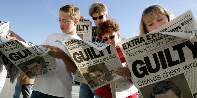 (L to R) Danny Lewin, Geoff Shenk, Katherine Lewin and Katie Lewin read the Extra edition put out by the Redwood City Daily News after the verdict was read in the Scott Peterson murder trial Nov. 12, 2004, in Redwood City, Calif.