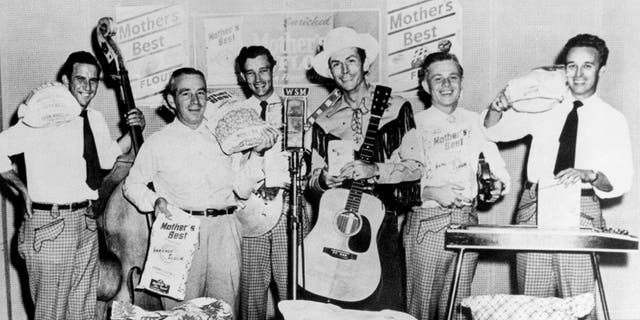 Hank Williams (center, hat and guitar) and the Drifting Cowboys pose at WSM Radio's studio in Nashville, Tennessee, circa 1950.