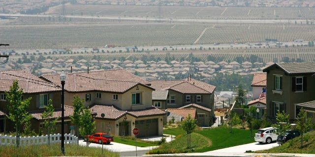 A gated community housing project overlooks a rural landscape that is being rapidly converted into a vast suburb as a construction boom continues in San Bernardino County.