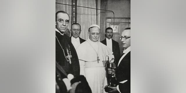 Pope Pius XI (1857-1939), center, on the Vatican radio station's inauguration, along with inventor Guglielmo Marconi (1874-1937), Feb. 1931, Vatican City.