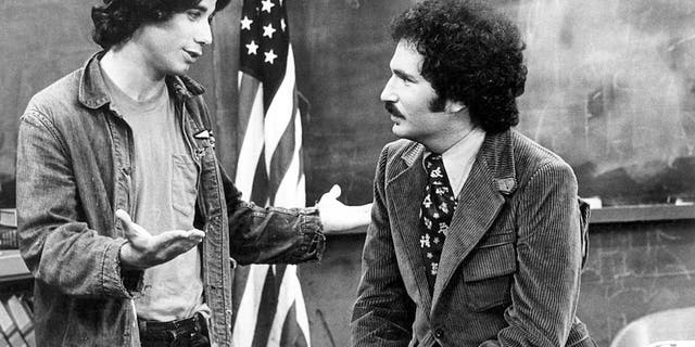 Gabe Kaplan (right) played Gabe Kotter, the teacher of a class of delinquents called the Sweathogs at his former high school; Vinnie Barbarino (John Travolta) was his student.