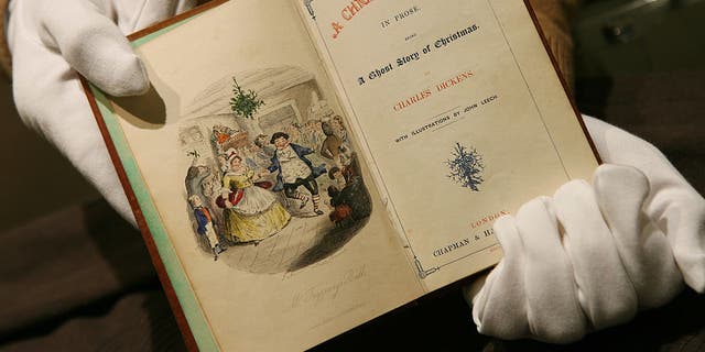 An employee at Sotheby's holds an 1843 first edition of the classic book "A Christmas Carol" by Charles Dickens in London, on Tuesday, December 5, 2006. 