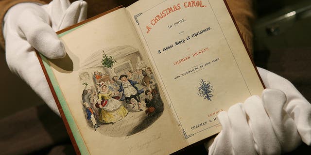 An employee at Sotheby's holds an 1843 first edition of the classic book "A Christmas Carol" by Charles Dickens in London, on Tuesday, December 5, 2006. 