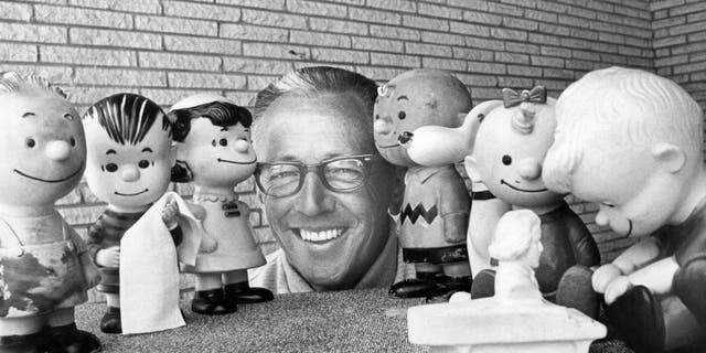 Portrait of American cartoonist Charles M Schultz (1922-2000) surrounded by rubber doll replicas of the characters in his "Peanuts" comic strip, California, October 1966. 