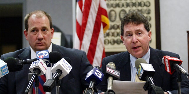 Northhampton County Coroner Zachery Lysek, left, and District Attorney John Morganelli talk about charges against nurse Charles Cullen, "The Angel of Death," who admitted using a syringe filled with stolen digoxin to kill dozens of patients as they lay in their beds at St. Luke's Hospital in Bethlehem, Pennsylvania.