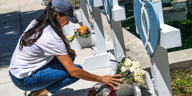 Meghan Markle, the wife of Britain's Prince Harry, places flowers as she mourns at a makeshift memorial outside Uvalde County Courthouse in Uvalde, Texas, on May 26, 2022.