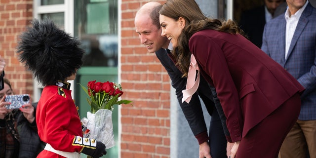 Prince William, Prince of Wales, and Catherine, Princess of Wales, meet a boy dressed as a guard at Greentown Labs, North America’s largest clean-tech incubator, Dec. 1, 2022, in Boston. 