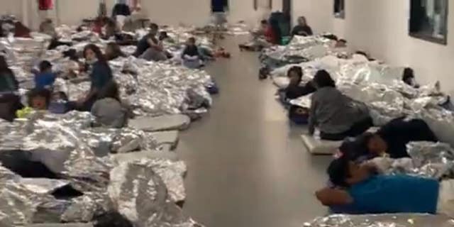 Migrants sprawled out on mattresses on the floor. 