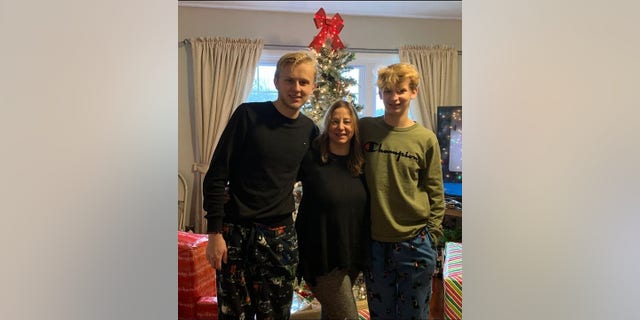 Ken DeLand, and American college student missing in France, is pictured with his mother and younger brother standing in front of a Christmas tree. 