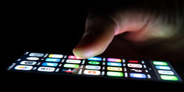 A man holds an iPhone in his hand in December 2022 in Baden-Wuerttemberg, Rottweil.