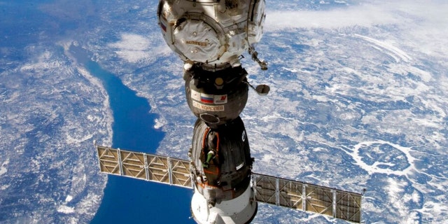 This undated handout photo taken by Russian cosmonaut Sergei Korsakov and released by Roscosmos State Space Corporation shows a Soyuz capsule of the International Space Station (ISS) during its fly.