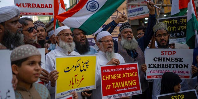 Indians hold placards as they shout slogans during a protest against China in Mumbai, India, Tuesday, Dec. 13, 2022. Soldiers from India and China clashed last week along their disputed border.
