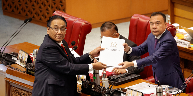 Bambang Wuryanto, head of the parliamentary commission overseeing the revision, passes the report of the new criminal code to Sufmi Dasco Ahmad, Deputy speaker of the House of Representatives, during a parliamentary plenary meeting in Jakarta, Indonesia.