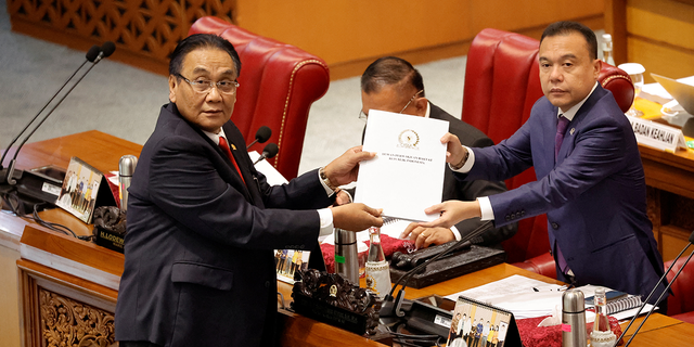 Bambang Wuryanto, head of the parliamentary commission overseeing the revision, passes the report of the new criminal code to Sufmi Dasco Ahmad, Deputy speaker of the House of Representatives, during a parliamentary plenary meeting in Jakarta, Indonesia.