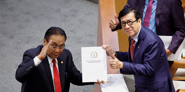 Yasonna Laoly, Indonesian Minister of Law and Human Rights, receives the new criminal code report from Bambang Wuryanto, head of the parliamentary commission overseeing the revision, during a parliamentary plenary meeting in Jakarta, Indonesia.