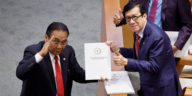 Yasonna Laoly, Indonesian Minister of Law and Human Rights, receives the new criminal code report from Bambang Wuryanto, head of the parliamentary commission overseeing the revision, during a parliamentary plenary meeting in Jakarta, Indonesia.