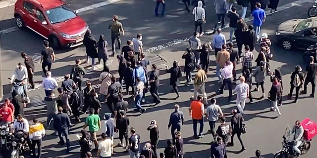 FILE: In this frame grab from a video, people are blocking an intersection during a protest to mark 40 days since the death in custody of 22-year-old Mahsa Amini, whose tragedy sparked Iran's biggest antigovernment movement in over a decade, in Tehran, Iran, Wednesday, Oct. 26, 2022.