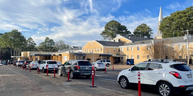 A line of cars meanders past several city blocks as workers from the Rapid Response Coalition of Mississippi hand out bottled water to residents of Jackson, Mississippi, on Tuesday, Dec. 27, 2022.
