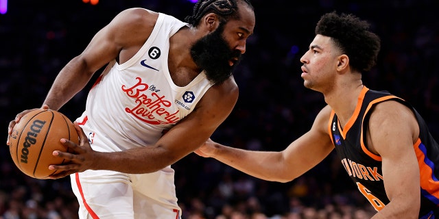 El escolta de los 76ers de Filadelfia, James Harden, busca superar al escolta de los Knicks de Nueva York, Quentin Grimes, durante la primera mitad de un partido de baloncesto de la NBA, el domingo 25 de diciembre de 2022, en la ciudad de Nueva York.