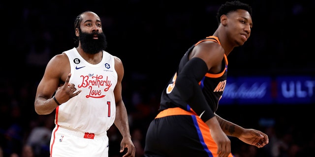 Le garde des Philadelphia 76ers James Harden (1) réagit après avoir fait un panier à trois points contre le garde des New York Knicks RJ Barrett lors de la première mi-temps d'un match de basket de la NBA, dimanche 25 décembre 2022, en Nueva York. 