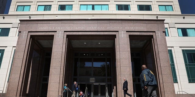 A member of the U.S. Marshals Service walks in front of the Federal District court for the Southern District of Florida.