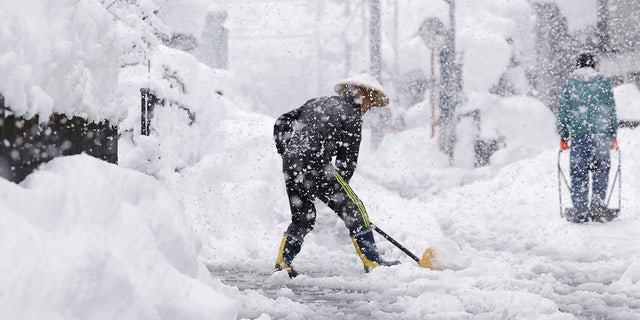 Residents remove snow during heavy snow Monday, Dec. 19, 2022 in Nagaoka, Niigata prefecture, northern Japan.(Kyodo News via AP)