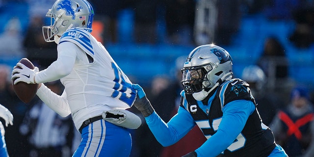 Detroit Lions quarterback Jared Goff looks to pass under pressure from Carolina Panthers defensive end Brian Burns during the second half of an NFL football game between the Carolina Panthers and the Detroit Lions on Saturday, Dec. 24, 2022, in Charlotte, N.C.