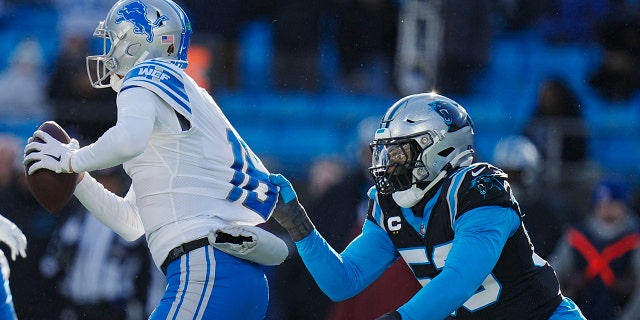 Detroit Lions quarterback Jared Goff looks to pass under pressure from Carolina Panthers defensive end Brian Burns during the second half of an NFL football game between the Carolina Panthers and the Detroit Lions on Saturday, Dec. 24, 2022, in Charlotte, N.C.