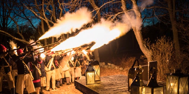 Members of the Glover's Marblehead Regiment, a contemporary group of reenactors, offer a salute to Revolutionary War hero General John Glover at his grave in Marblehead, Massachusetts. 