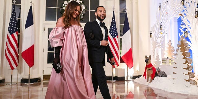 Hollywood power couple John Legend and Chrissy Teigen arrive at the White House to attend a state dinner honoring French President Emmanuel Macron, in Washington, DC, on December 1, 2022. 