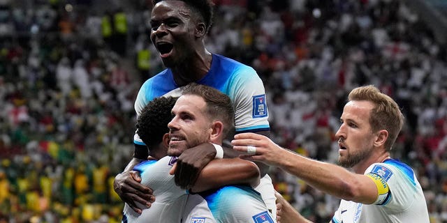 England's Jordan Henderson, center, celebrates with his teammates after scoring his side's first goal during the World Cup match against Senegal at Al Bayt Stadium in Al Khor, Qatar, Dec. 4, 2022.