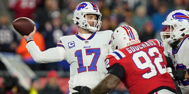 Buffalo Bills quarterback Josh Allen, #17, throws under pressure from New England Patriots defensive tackle Davon Godchaux, #92, during the first half of an NFL football game, Thursday, Dec. 1, 2022, in Foxborough, Massachusetts.