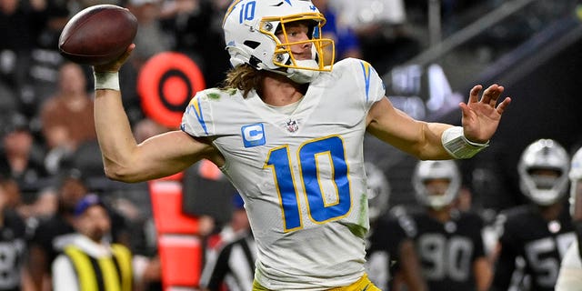 Los Angeles Chargers quarterback Justin Herbert (#10) will face Las Vegas Raiders defensive end Max Crosby (#98) during the second half of an NFL football game in Las Vegas on Sunday, December 4, 2022. ) and passed under pressure.
