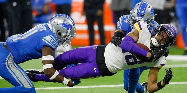 Minnesota Vikings' Justin Jefferson is stopped by Minnesota Vikings' Kerby Joseph and Amani Oruwariye during the second half, Sunday, Dec. 11, 2022, in Detroit.