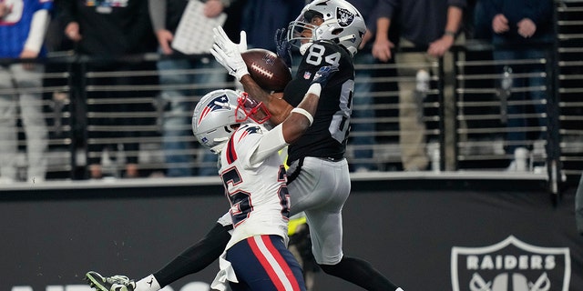 Las Vegas Raiders wide receiver Keelan Cole, #84, catches a 30-yard touchdown pass against New England Patriots cornerback Marcus Jones, #25, during the second half of an NFL football game between the New England Patriots and Las Vegas Raiders, Sunday, Dec. 18, 2022, in Las Vegas. 