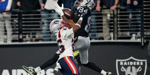 Las Vegas Raiders wide receiver Keelan Cole, #84, catches a 30-yard touchdown pass against New England Patriots cornerback Marcus Jones, #25, during the second half of an NFL football game between the New England Patriots and Las Vegas Raiders, Sunday, Dec. 18, 2022, in Las Vegas. 