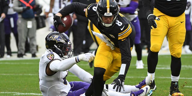 Pittsburgh Steelers quarterback Kenny Pickett, #8, slips out of the grasp of Baltimore Ravens linebacker Patrick Queen, #6, during the first half of an NFL football game in Pittsburgh, Sunday, Dec. 11, 2022. 