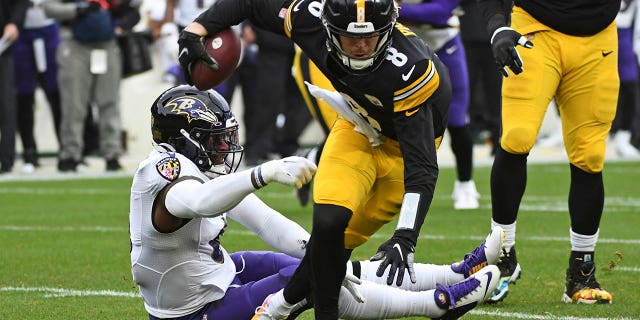 Pittsburgh Steelers quarterback Kenny Pickett, #8, slips out of the grasp of Baltimore Ravens linebacker Patrick Queen, #6, during the first half of an NFL football game in Pittsburgh, Sunday, Dec. 11, 2022.