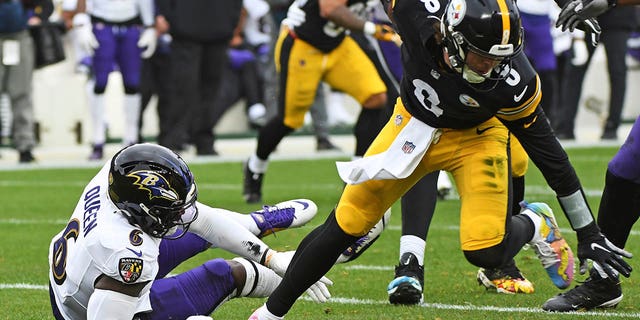 Pittsburgh Steelers quarterback Kenny Pickett (8) is nearly tackled by Baltimore Ravens linebacker Patrick Queen (6) during the first half in Pittsburgh, Sunday, Dec. 11, 2022.