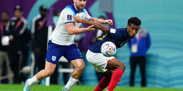 France's Kingsley Coman, right, and England's Luke Shaw battle for the ball during the World Cup quarterfinal match at the Al Bayt Stadium in Al Khor, Qatar, Dec. 10, 2022.